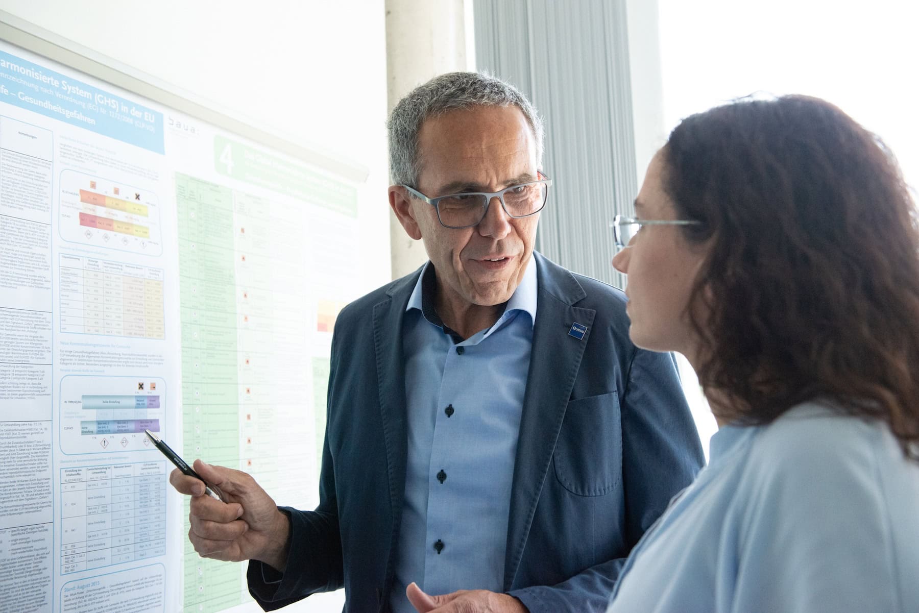 Beratung zur Arbeitssicherheit vor einem Aushang