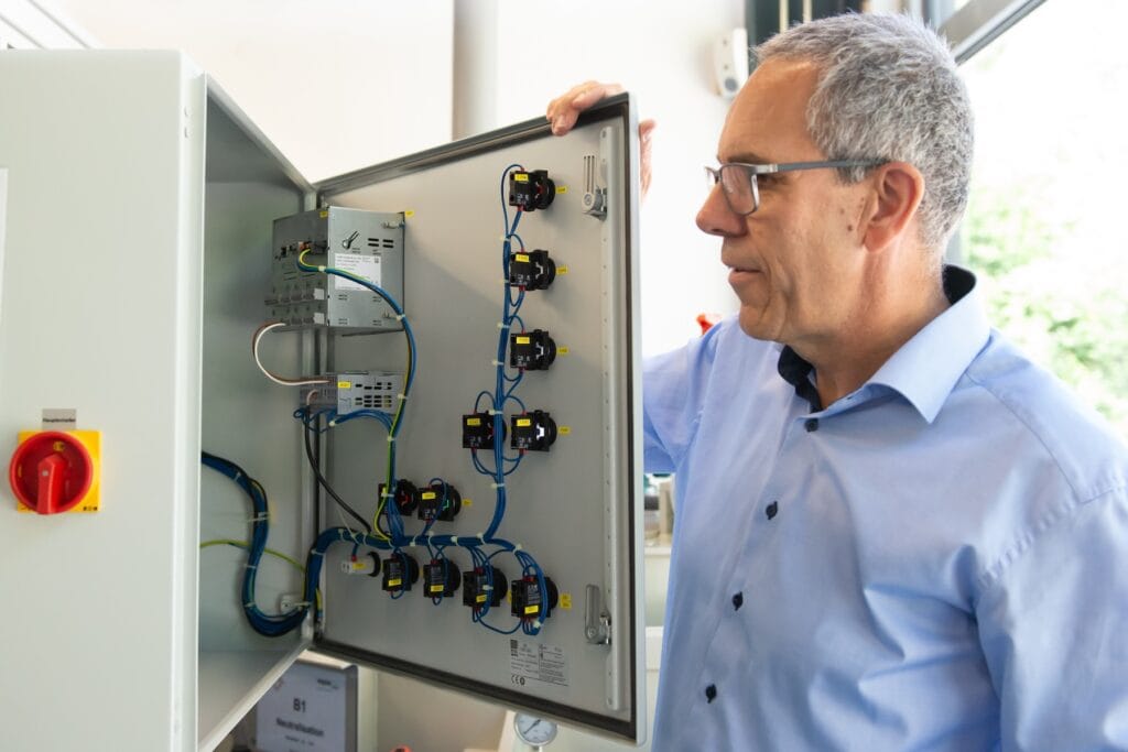 A consultant is inspecting an open control cabinet