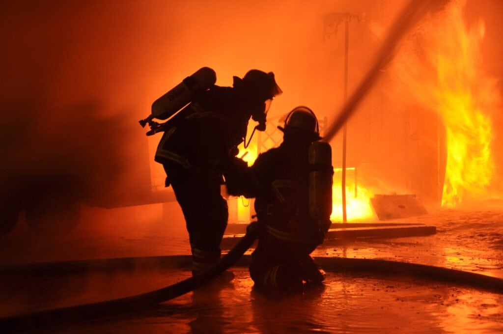 Firefighters wearing breathing apparatus whilst putting out a fire