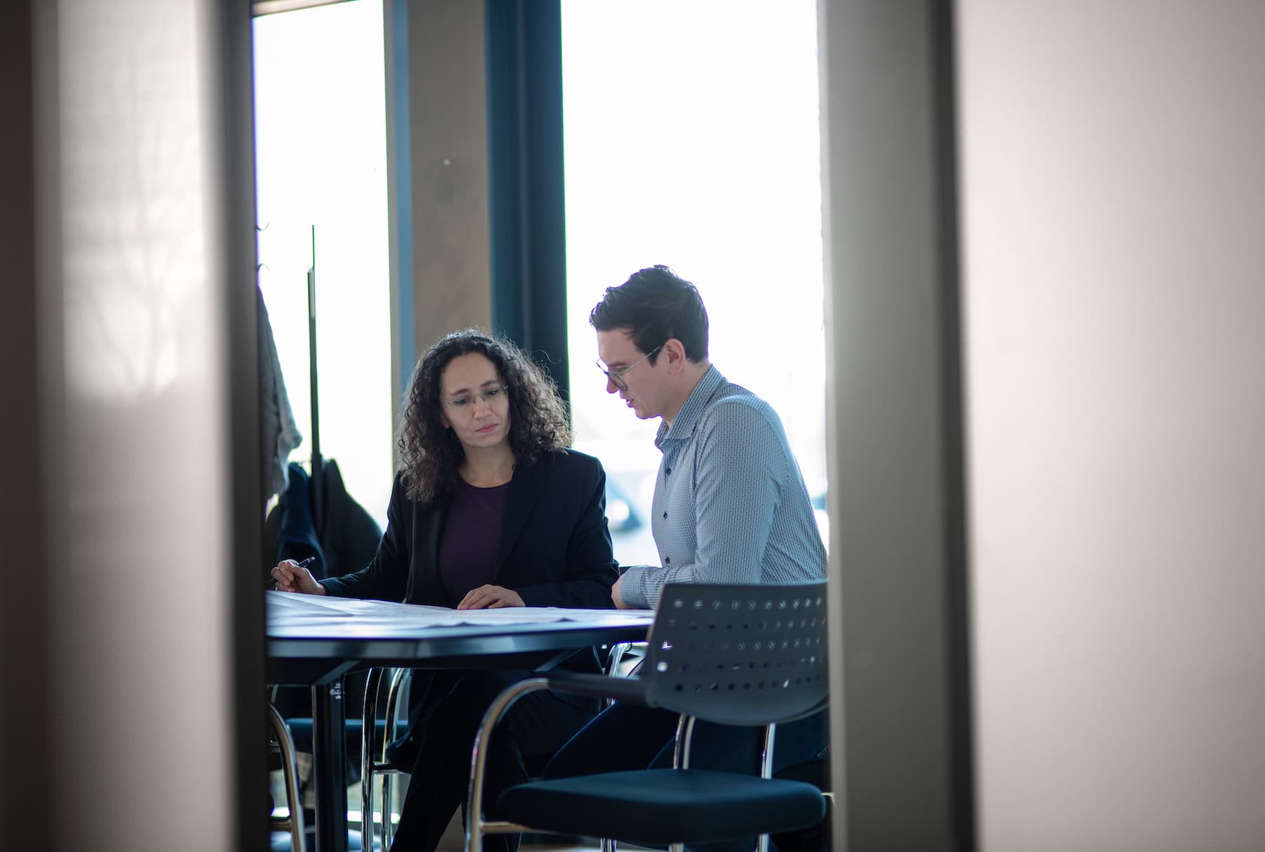Two consultants in conversation at the conference table